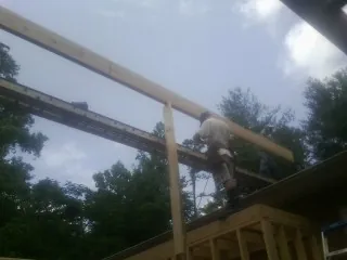 Carpenter setting a ridge beam over a new addition frame — Ice Dam Removal by Roofing Brothers in Rye Beach