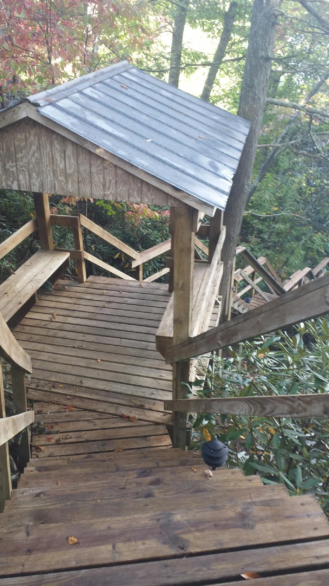 Metal roofed shelter over wooden steps on a wooded walkway — Skylight Repair & Installation work by our crew in Rye Beach